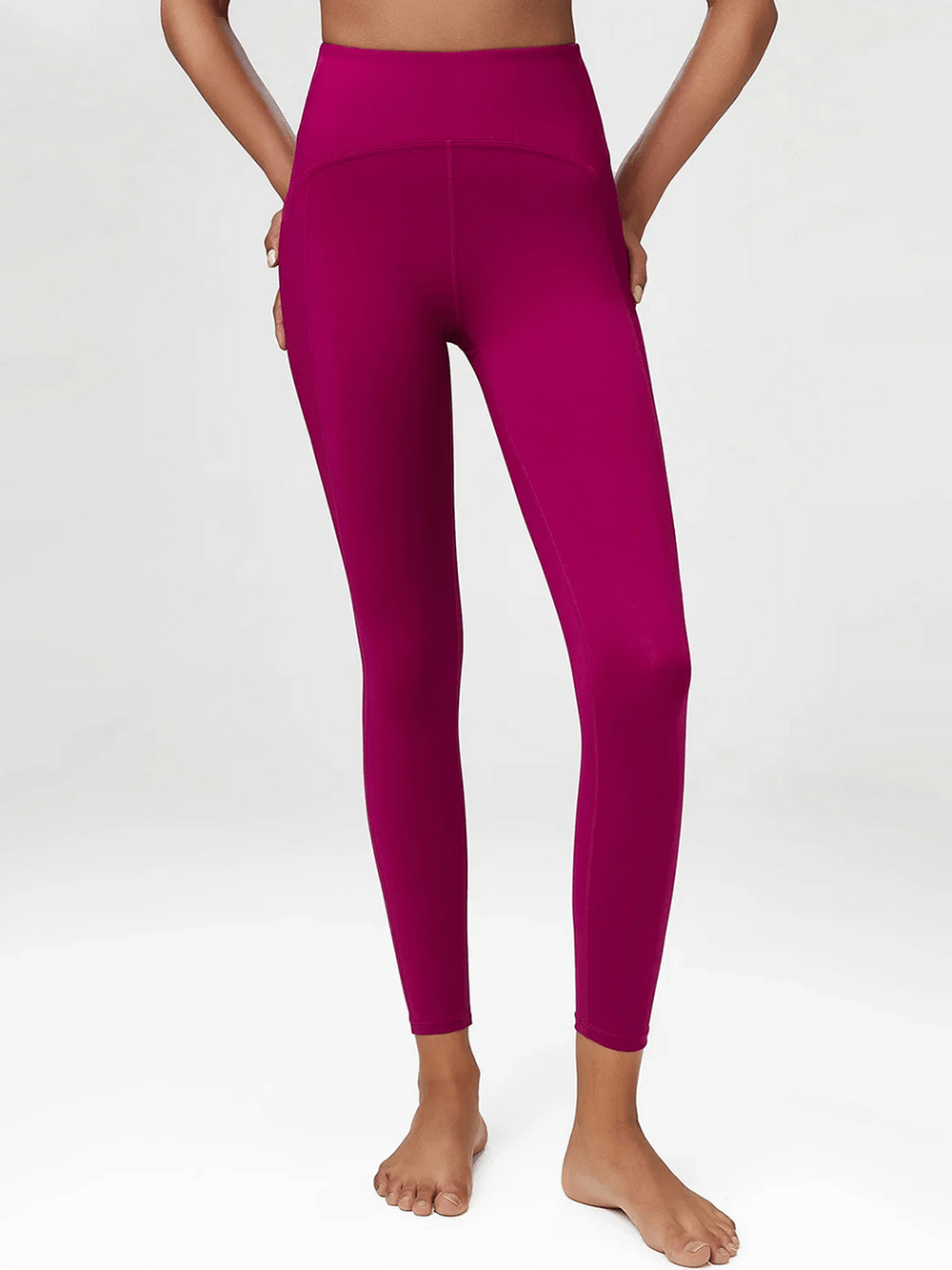 Woman wearing stylish rose red yoga leggings, perfect for gym, dance, or running. Features a snug fit with a nylon-spandex blend.